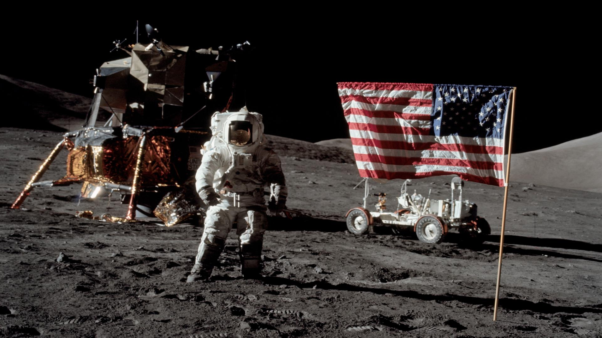 a NASA astronaut on the moon beside the American flag
