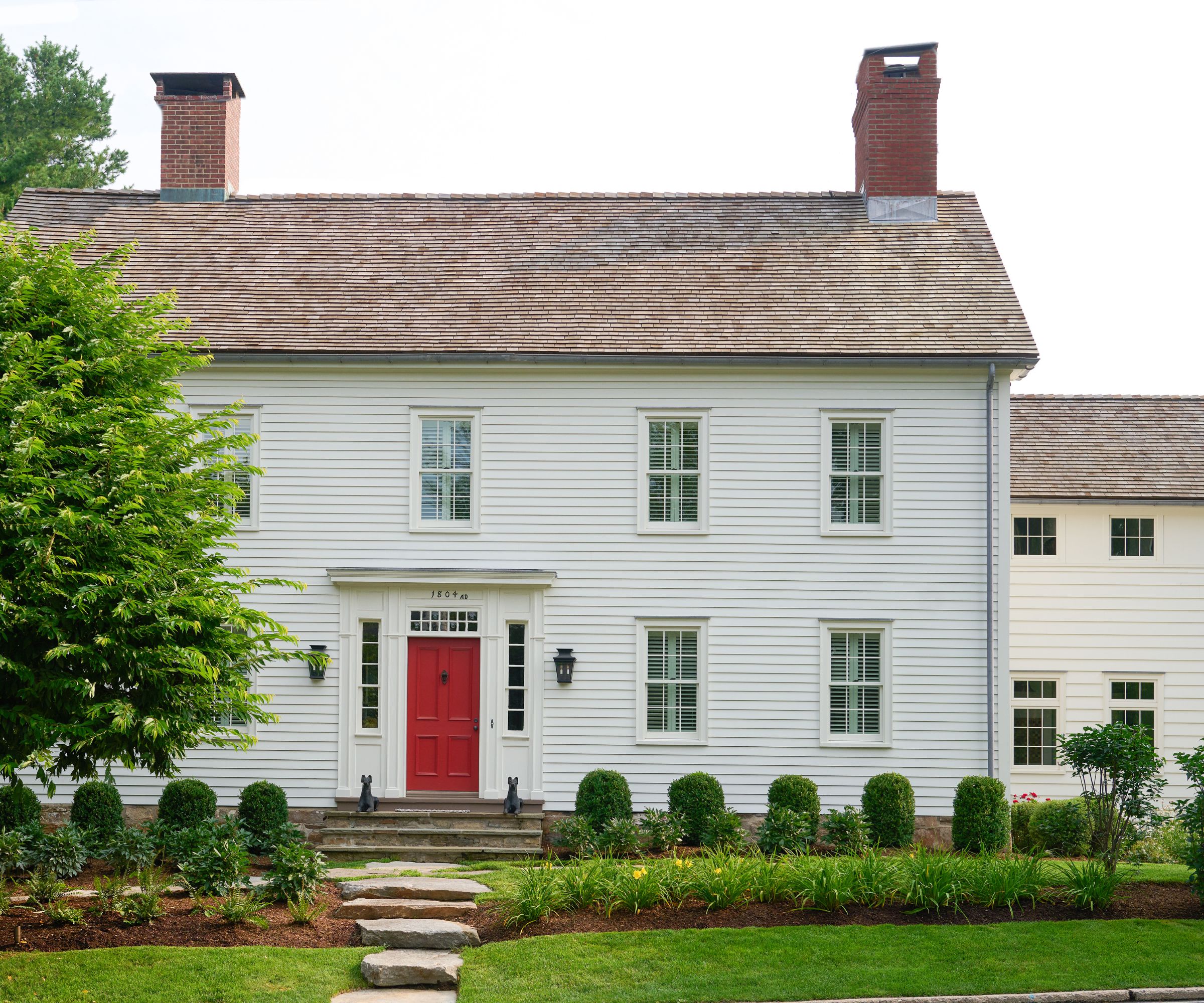 White wood paneled house with red door