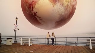 In the online movie "Miniverse," former astronaut Chris Hadfield and astronomer Laura Danly look at Pluto looming over a California pier.