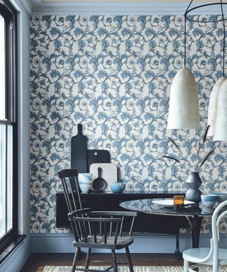 dining room with blue woodowrk, ornate blue wallpaper and a round black dining table