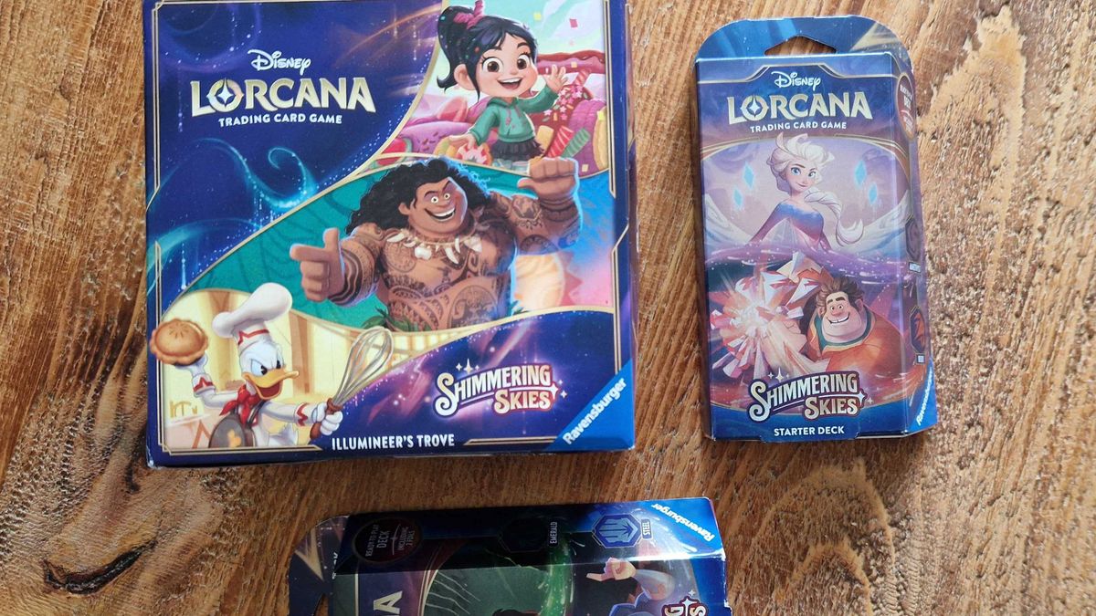 Disney Lorcana Shimmering Skies Illumineer&#039;s Trove and starter sets on a wooden surface