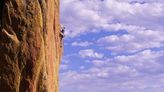 rock climbing terms: man on steep rock face