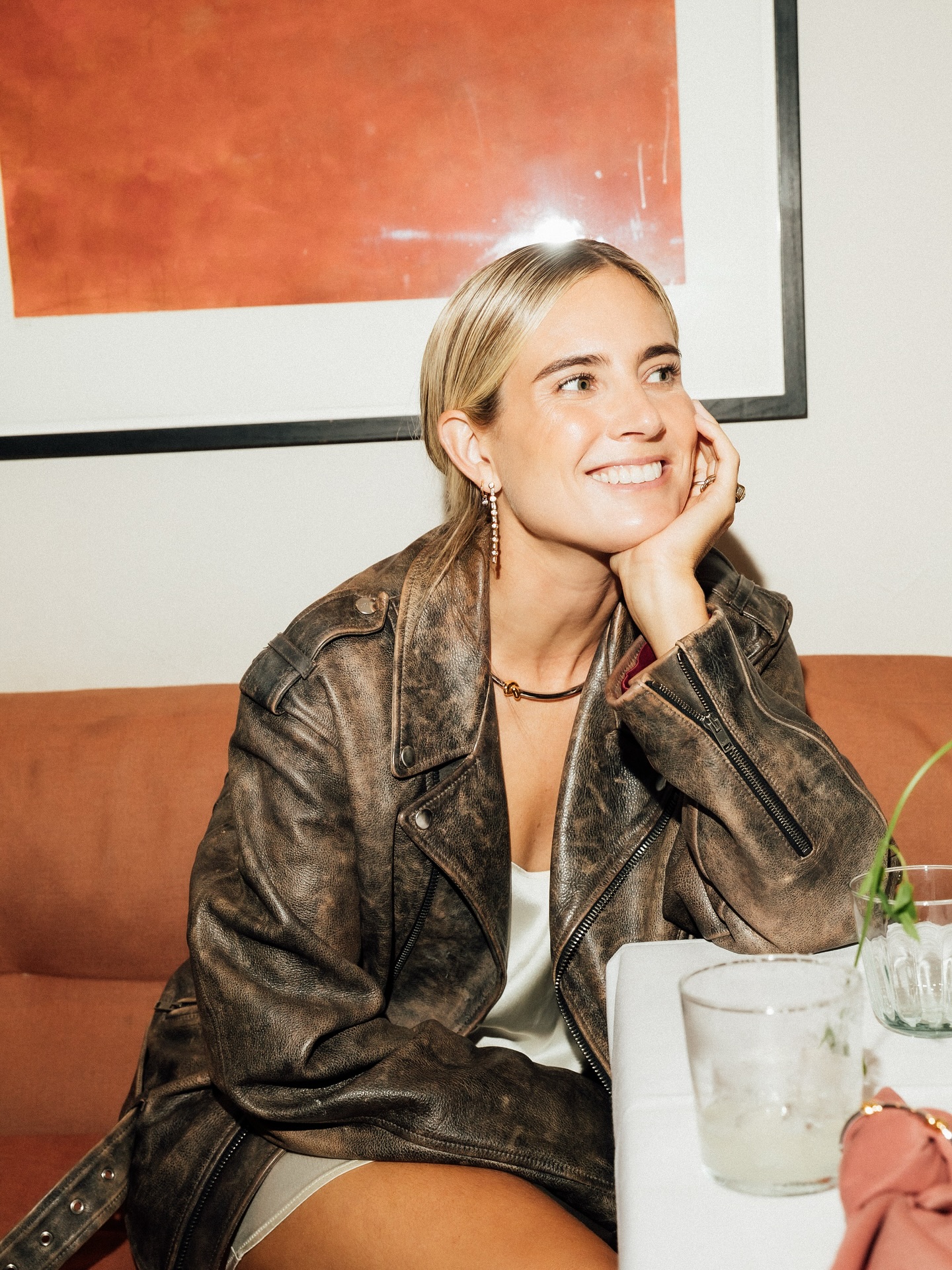 An image of @lucywilliams02 wearing a satin mini dress with a distressed leather jacket.