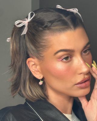 Hailey Bieber with braided pigtails and bows