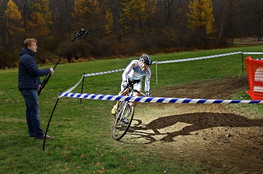 Adam Myerson (Cycle-Smart Grassroots Team) takes the corner with skill and his very own lighting expert.