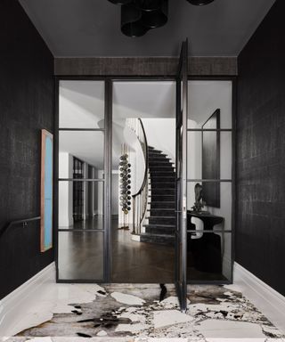 White staircase, black carpet, black framed glass windows, marble floor