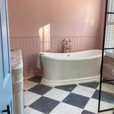 pink bathroom with pink walls and roll top bath