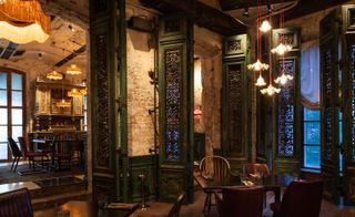 Kazbek restaurant in Moscow with wood and metal shutters, wooden floor and brown and green furniture