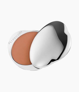 An open refillable silver compact case of Fluff vegan makeup bronzing powder against grey background