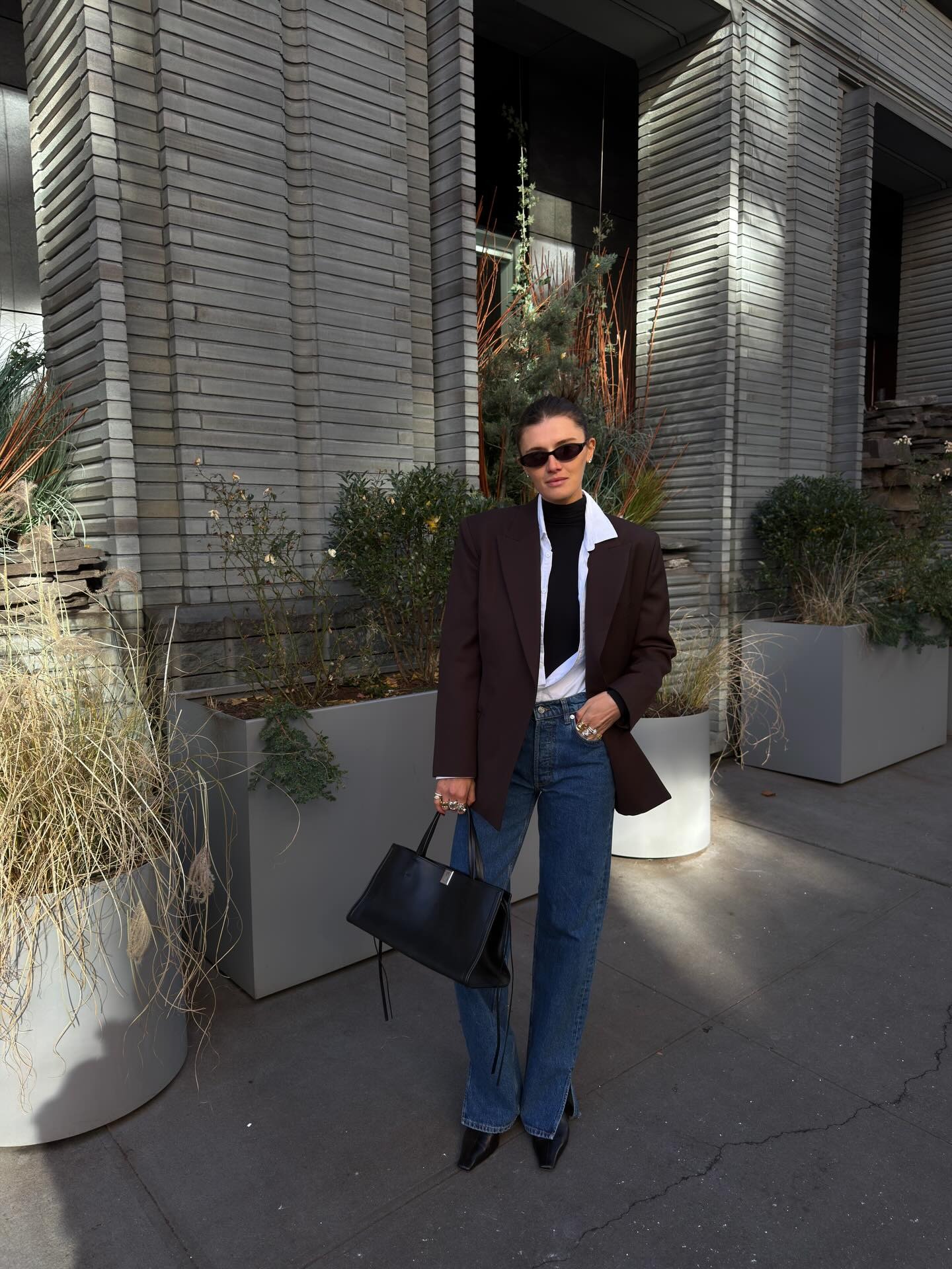 Influencer @cocoschiffer wears chisel toe boots with flares jeans and a blazer.