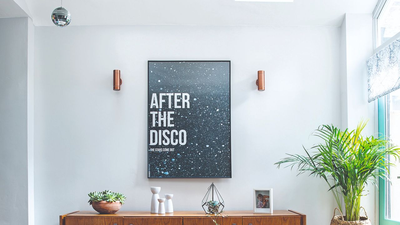 Disco-themed art print on the wall with a disco ball hanging from the ceiling