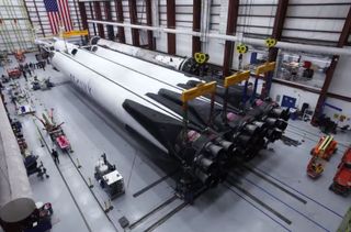 SpaceX engineers assemble the second heavy-lift Falcon Heavy rocket for the April 2019 launch of the Arabsat 6a communications satellite in a SpaceX hangar at NASA's Kennedy Space Center in Florida.