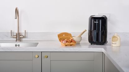 T-fal Compact air fryer in kitchen on countertop with carton of eggs and salt
