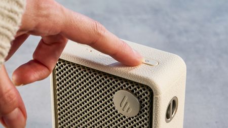 Edifier ES20 Bluetooth speaker in ivory colorway photographed on a blue background