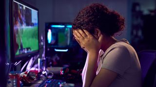 Upset gamer with her head in her hands