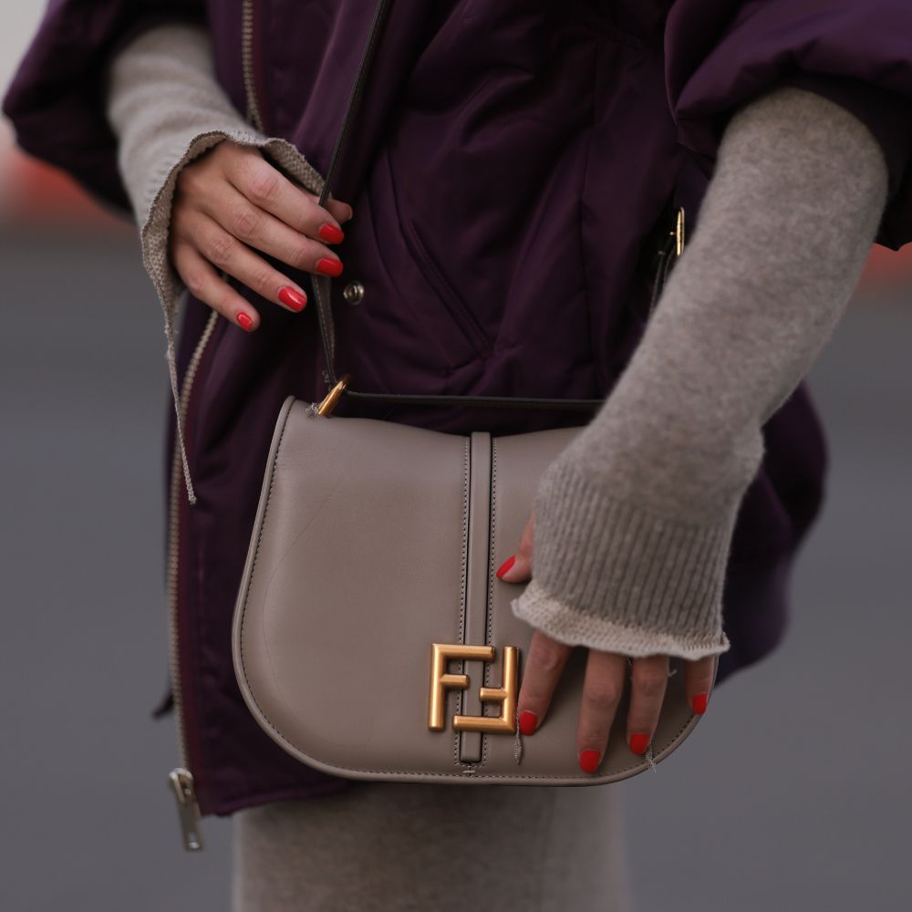 Close up of street style image showing woman's hands wearing red nail polish