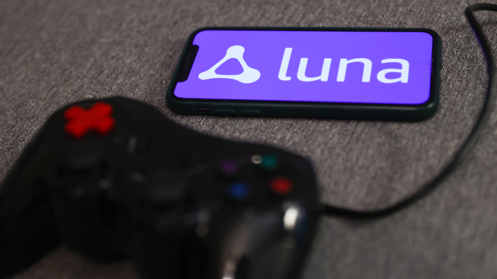 Luna logo displayed on a phone screen and a gamepad are seen in this illustration photo taken in Krakow, Poland on September 29, 2022. 