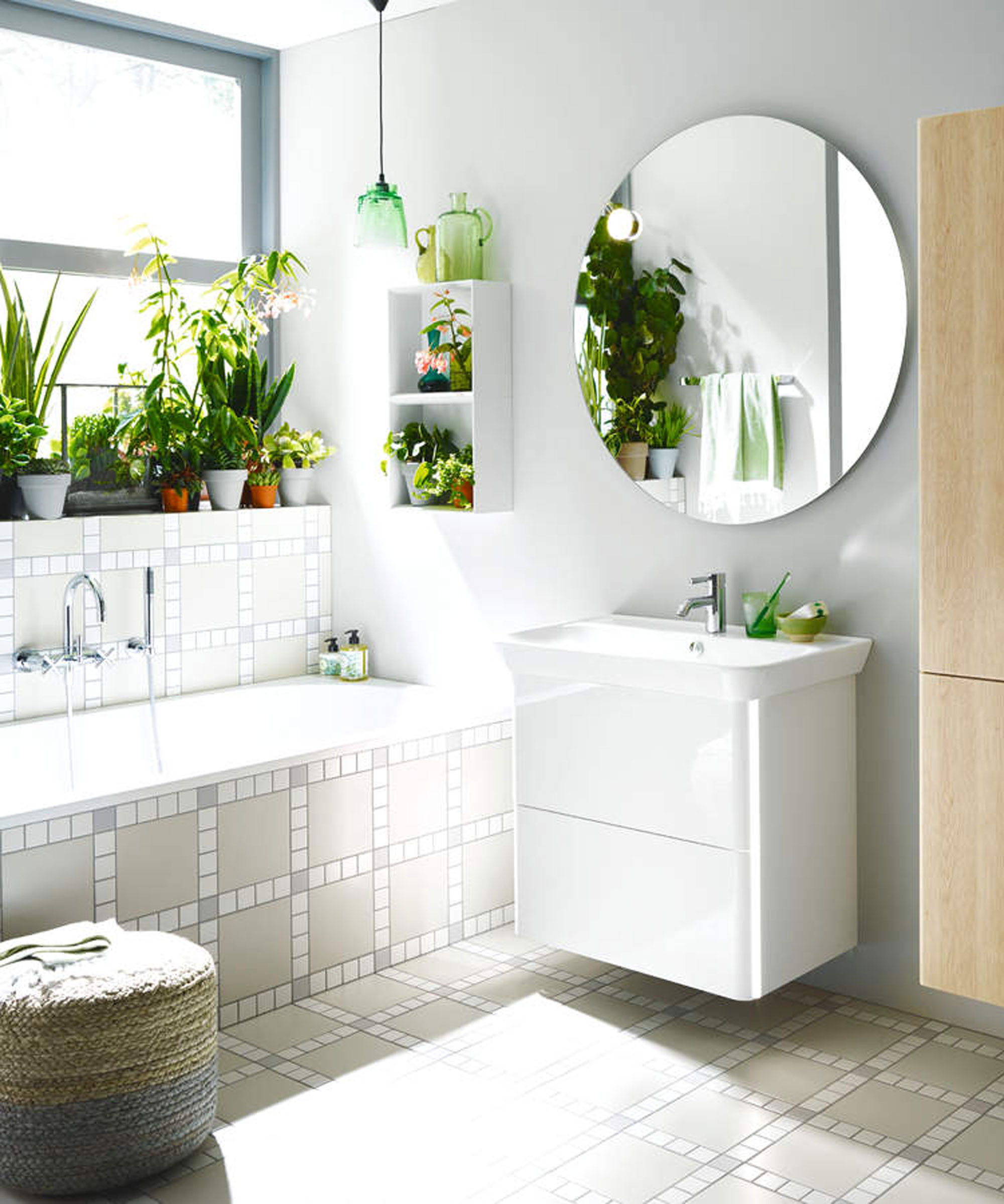 fresh bathroom with potted houseplants along windowsill and large round wall mirror