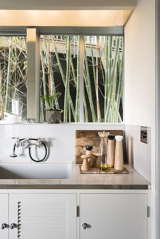 Sink and white cupboards with wooden decoration on top