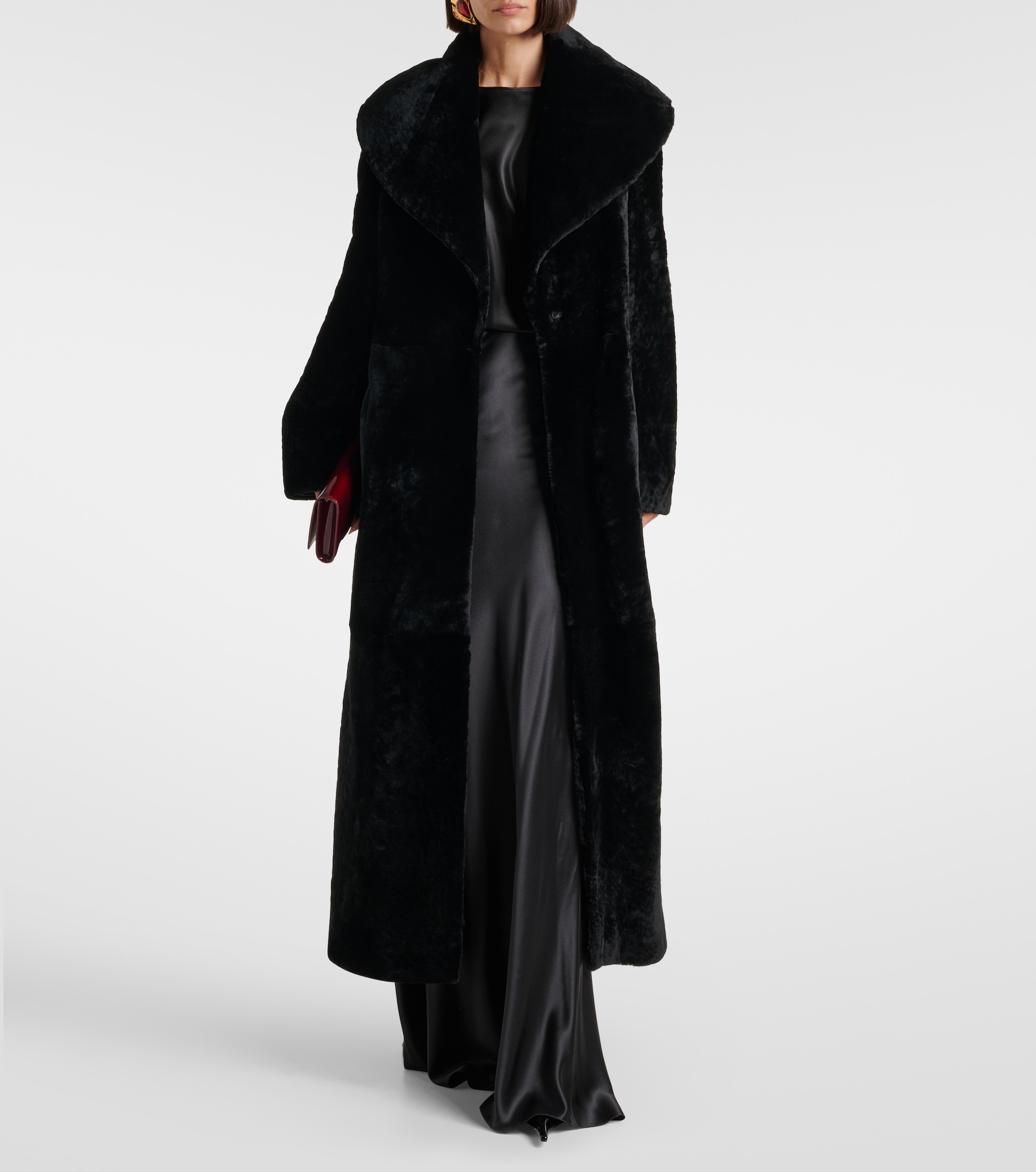 a model wearing a black shearling nour hammour coat