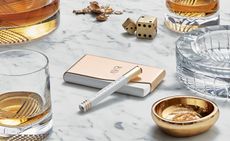 Whisky carafe, glasses, Dice, ashtray and vape on a marble table