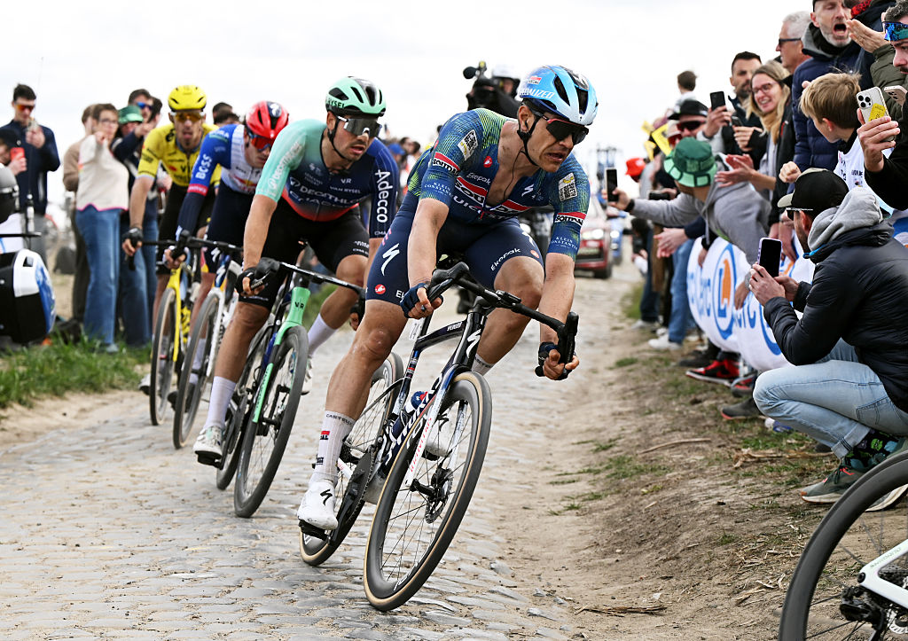 Jasper Stuyven leads a chasing group around a dusty, cobbled corner during Paris-Roubaix 2026