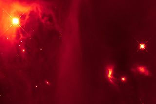 This infrared image from the Hubble Space Telescope contains a bright, fan-shaped object (lower right quadrant) thought to be a binary star that emits light pulses as the two stars interact. The primitive binary system is located in the Perseus molecular cloud.
