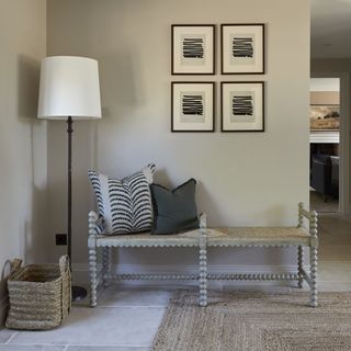 entryway with bench seating area and four pieces of artwork on the wall