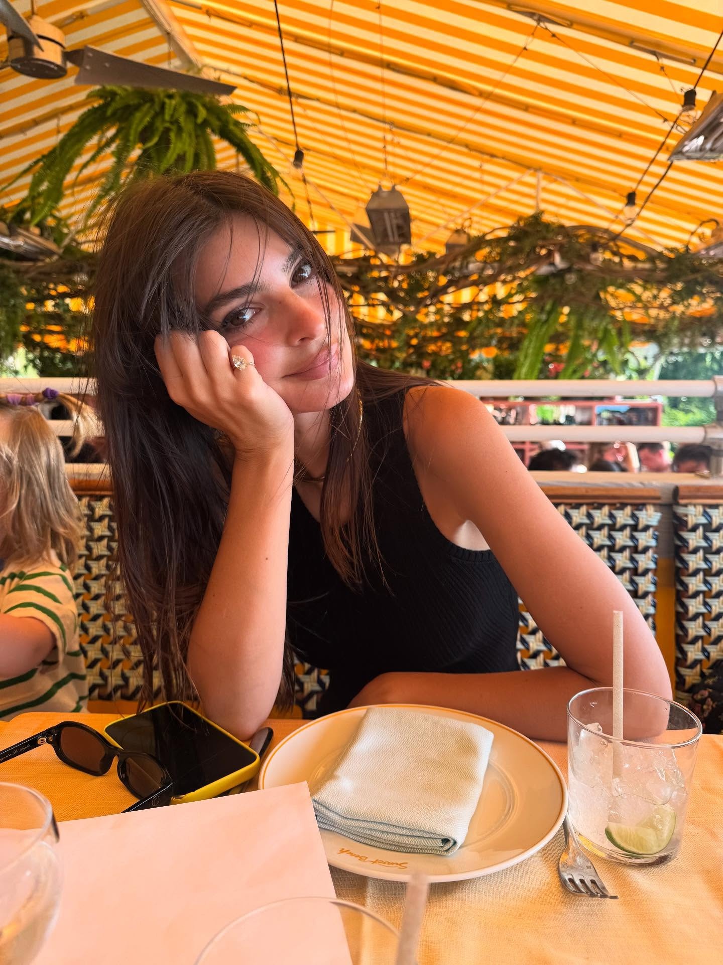 Emrata wears a pinky ring and black tank top.
