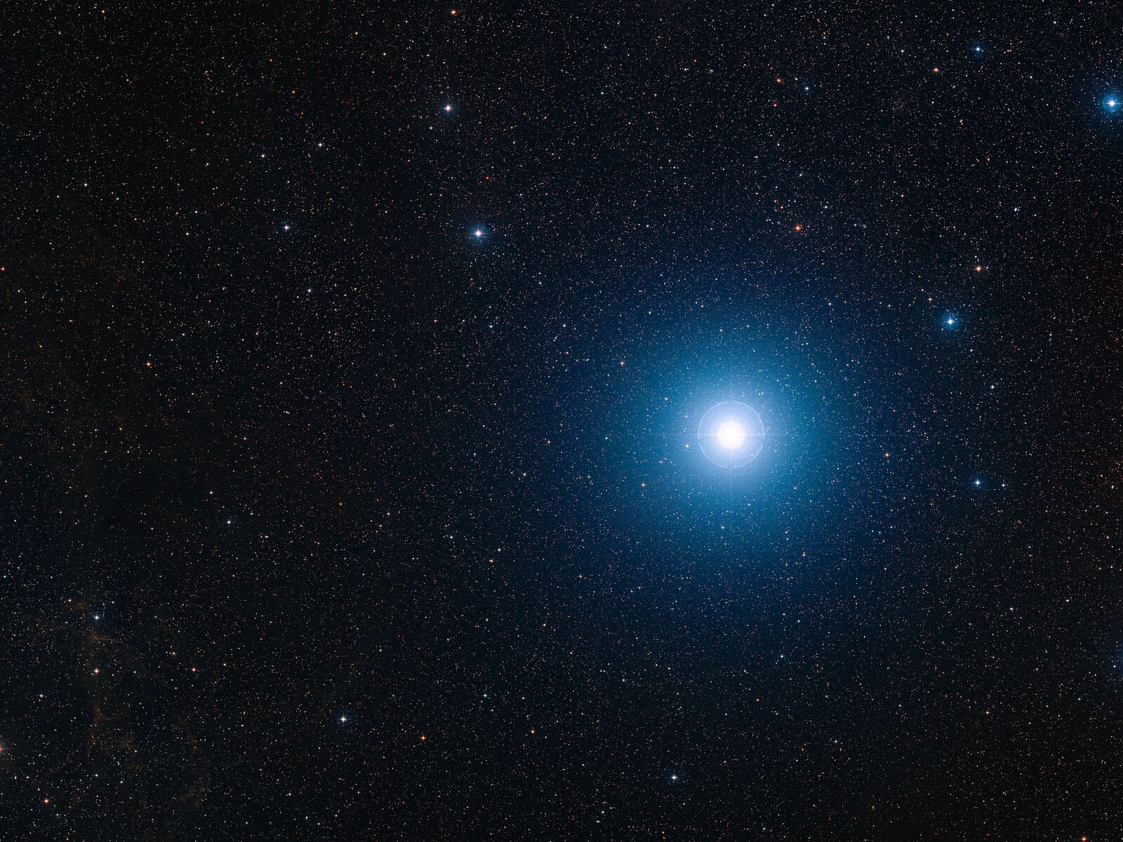 A bright ball of blue white light from a white dwarf star glows in the center right of the image against a dark starry background