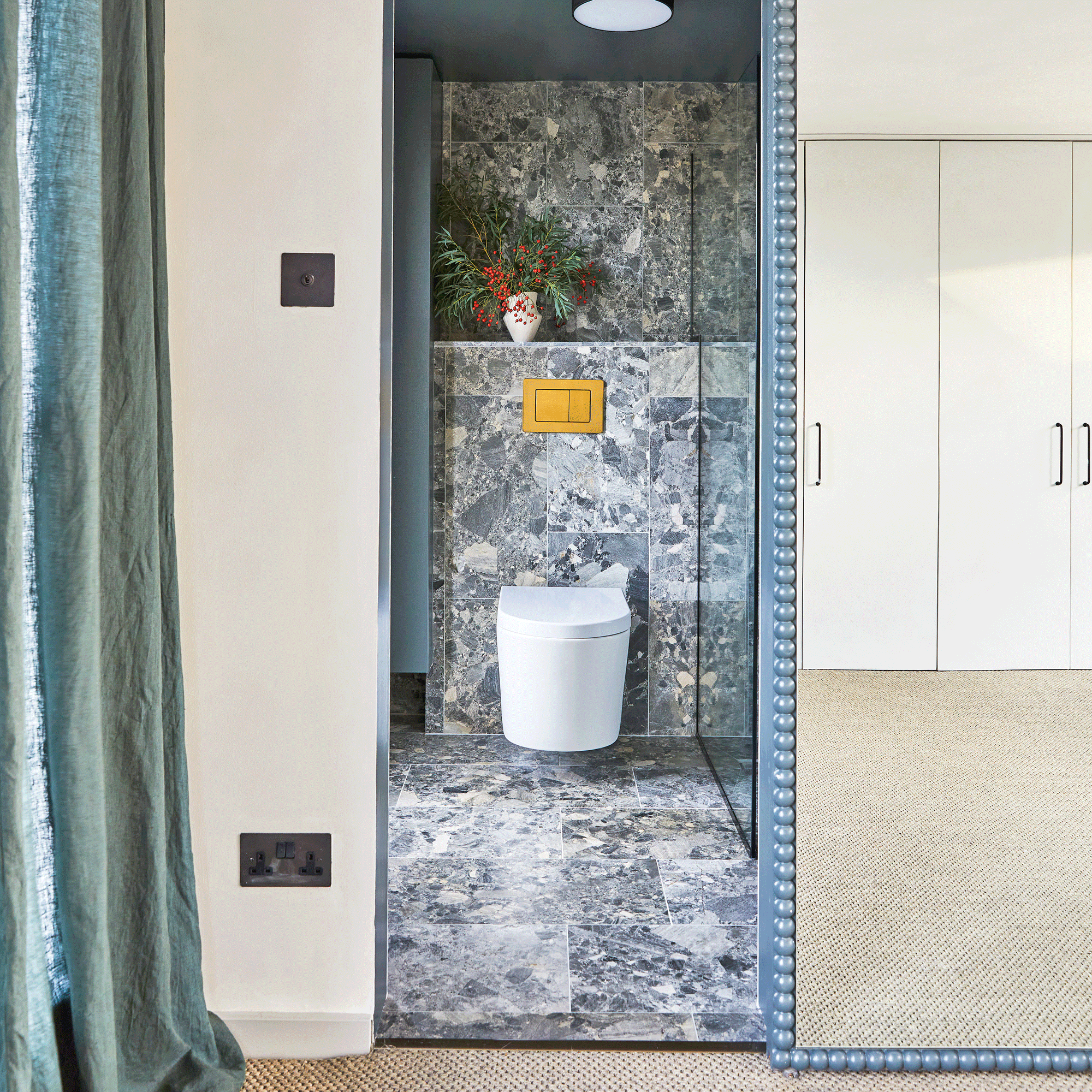 a loft bedroom with an en suite hidden behind a sliding door covered in a framed mirror
