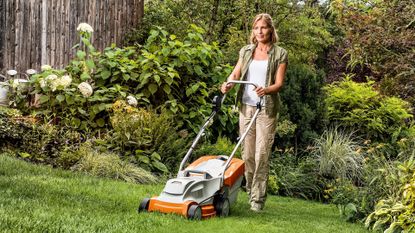 Stihl RMA 235 lawn mower being used by an adult woman to cut grass