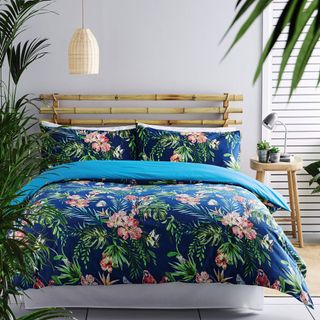 bedroom with floral pattern vivid blue tropics duvet set and two pillow cases and potted plant