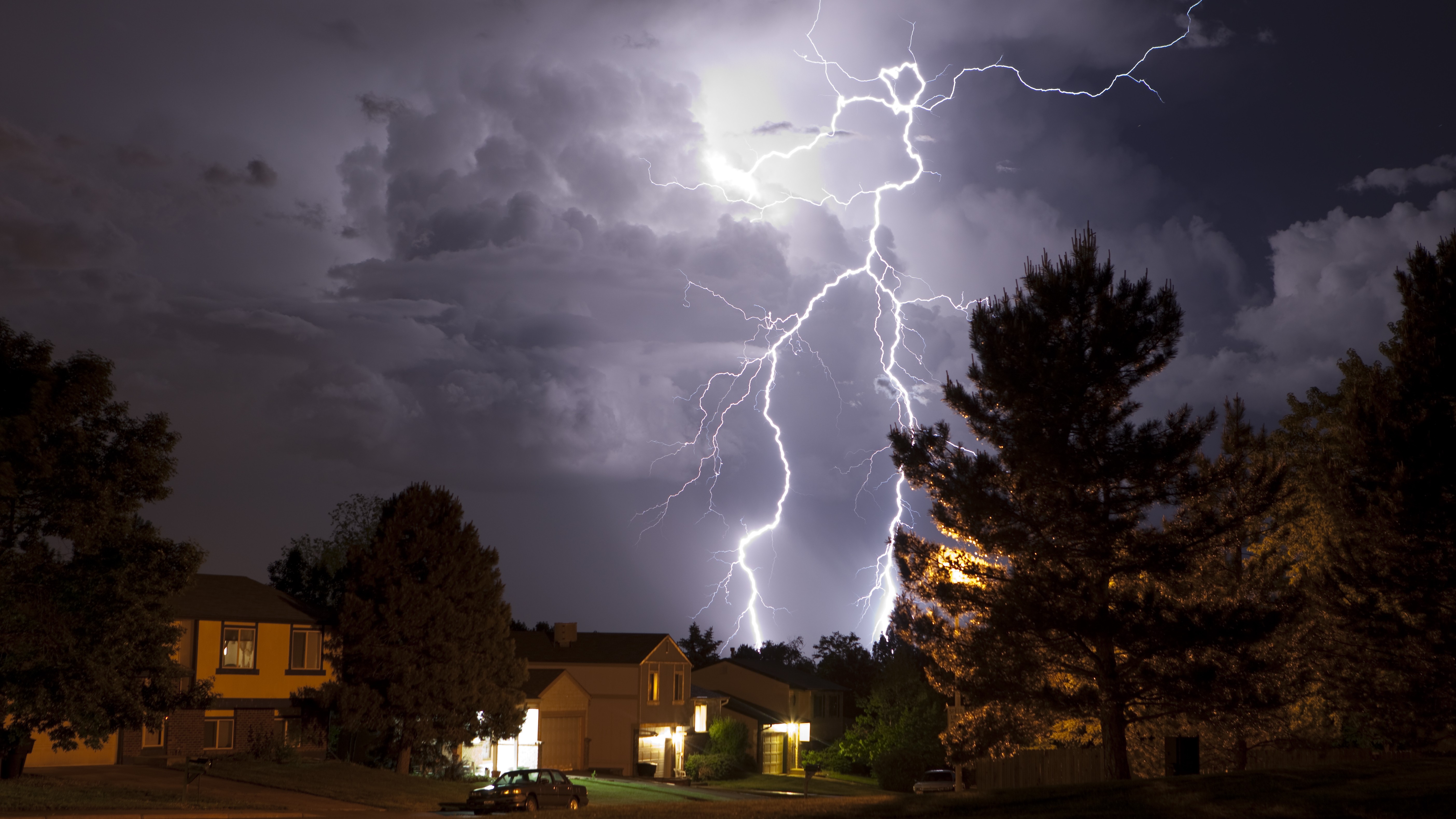A photograph of lightning striking over a suburb in Denver, Colorado.