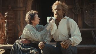 Olivia Colman leaning in to fix something on Alexander Skarsgard in Wicker