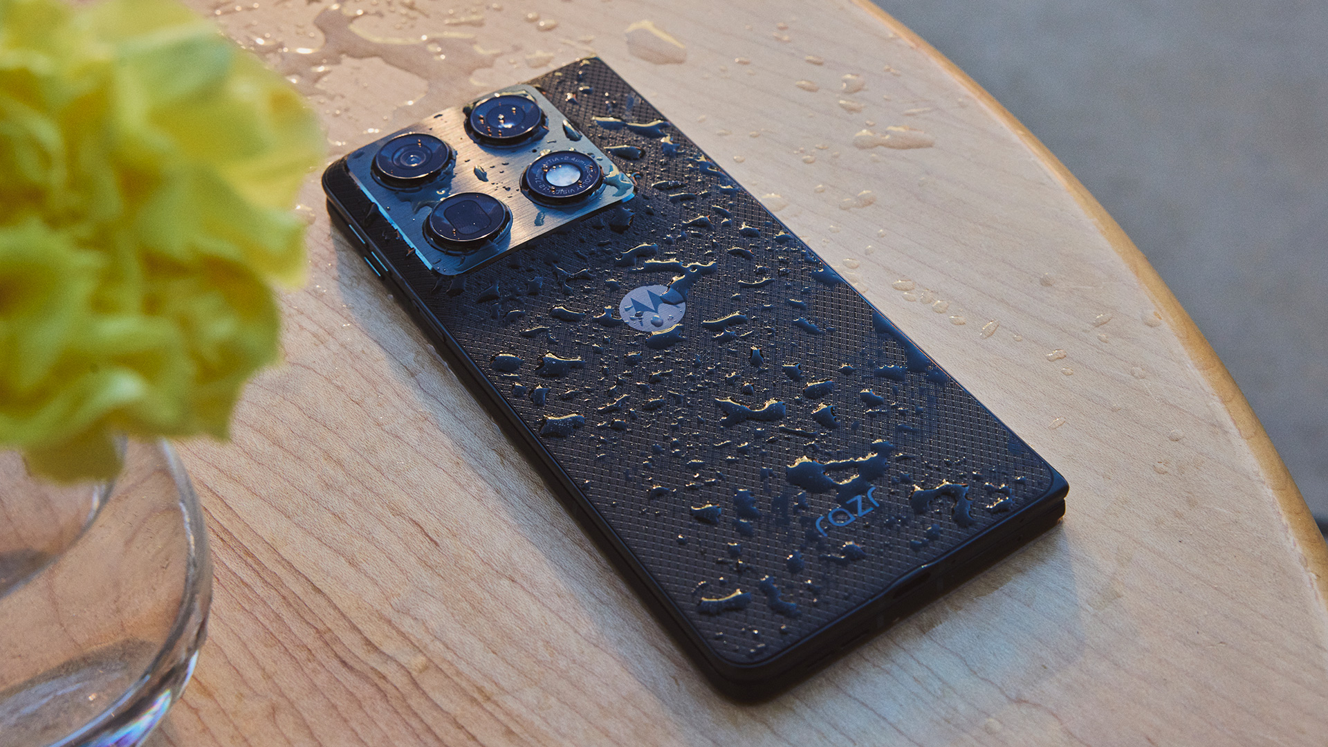Motorola Razr Fold face down on desk with water splashed on it to demonstrate water resistance