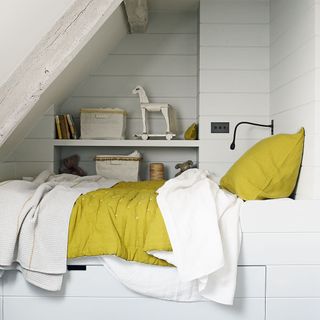 white attic snug bedroom with bed and wall shelf