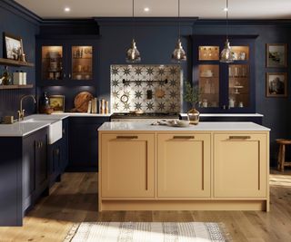 kitchen with yellow painted island, blue cupboards and cream tiles with gold star design