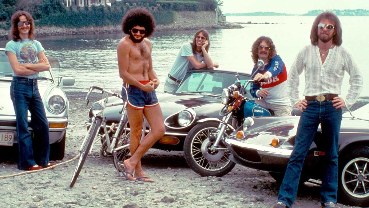 Boston posing on the beach with three Porsches