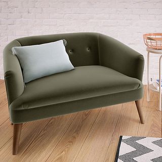grey coloured velvet sofa with cushion