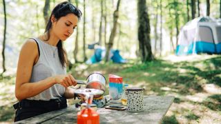 A woman making coffee at camp