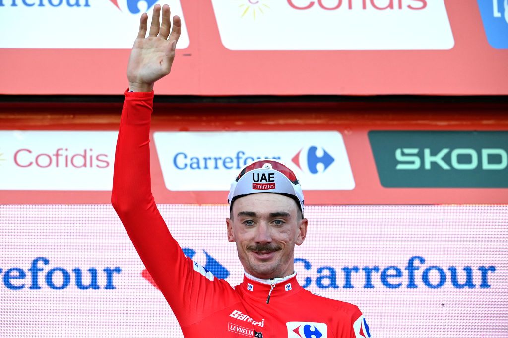 Team UAE&#039;s Brandon McNulty waves from the podium, wearing the red jersey of the general ranking leader after winning the stage 1 of La Vuelta a Espana cycling tour, a 12 km time-trial race from Lisbon to Oeiras, on August 17, 2024. (Photo by MIGUEL RIOPA / AFP)