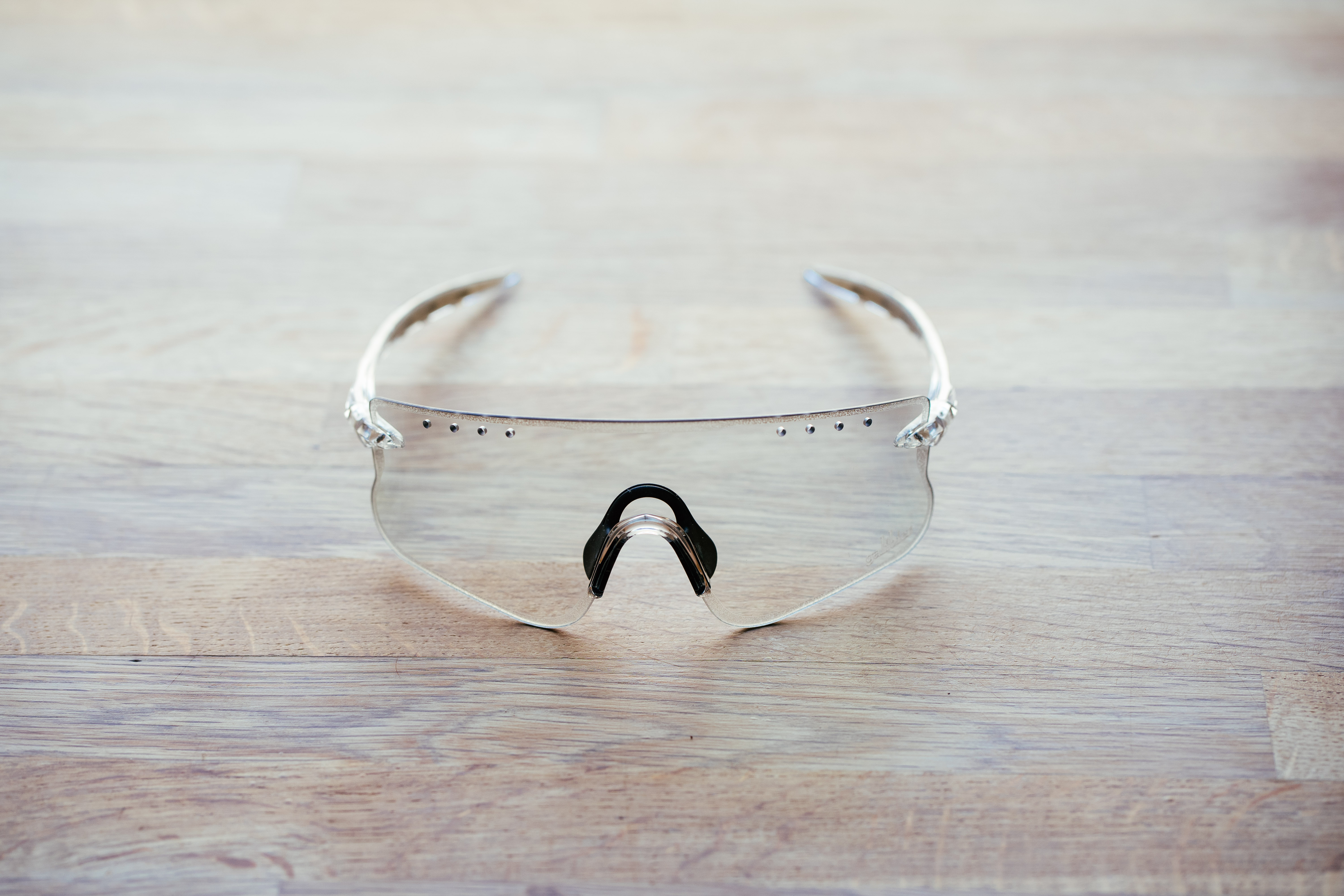 A clear pair of sports glasses on a wooden surface