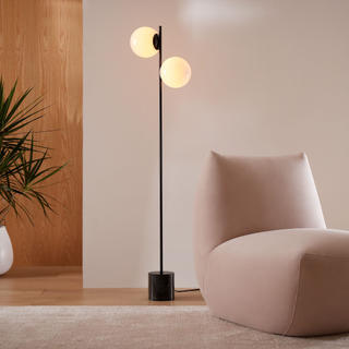 Large globe floor lamp in living room with pink sofa 