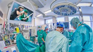 Surgeons in the operating room with AC/DC on the television