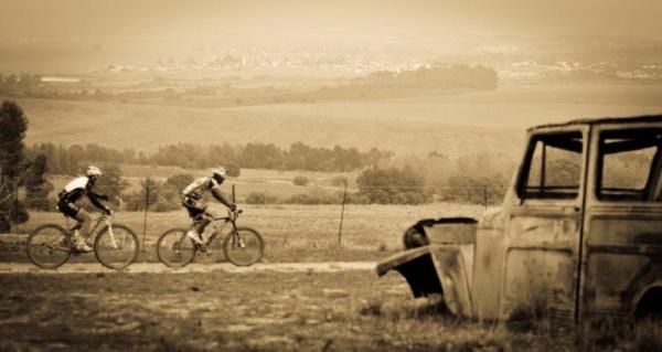 Kevin Evans and Adrien Niyonshuti pass a wreck in the mist