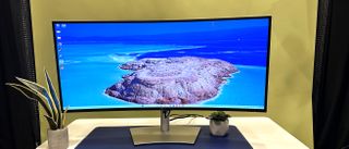 Dell UltraSharp 40 Thunderbolt Curved Hub Monitor on a desk with an island scene on the screen