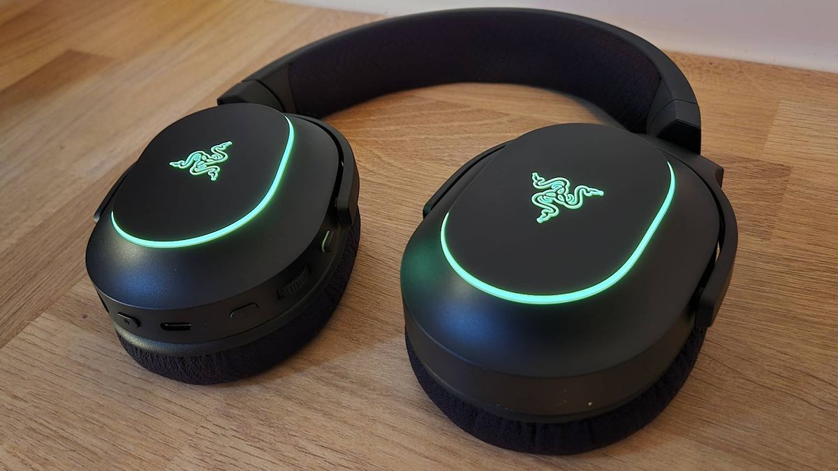Image of the Razer Barracuda X Chroma gaming headset on a wooden countertop.