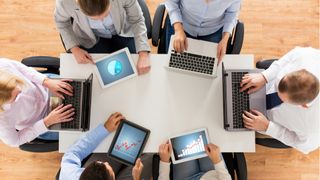 People on laptops around a table.