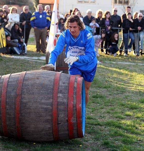 Filippo Pozzato rolling what appears to be a barrel of wine.